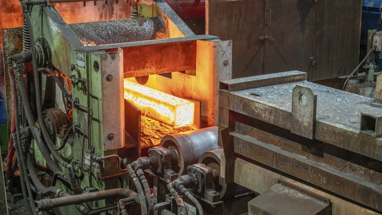 Ein sogenannter Stahlknüppel rollt aus dem Ofen ins Walzwerk. Feralpi schmilzt in Riesa aus Schrott neuen Stahl, der dann weiter zu Baustahl verarbeitet wird.