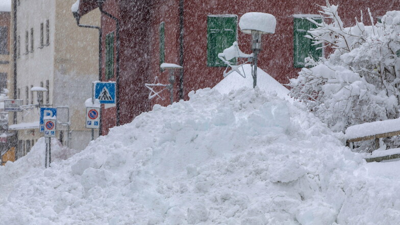 Schnee liegt hoch aufgetürmt am Straßenrand in der italienischen Gemeinde Brenner.