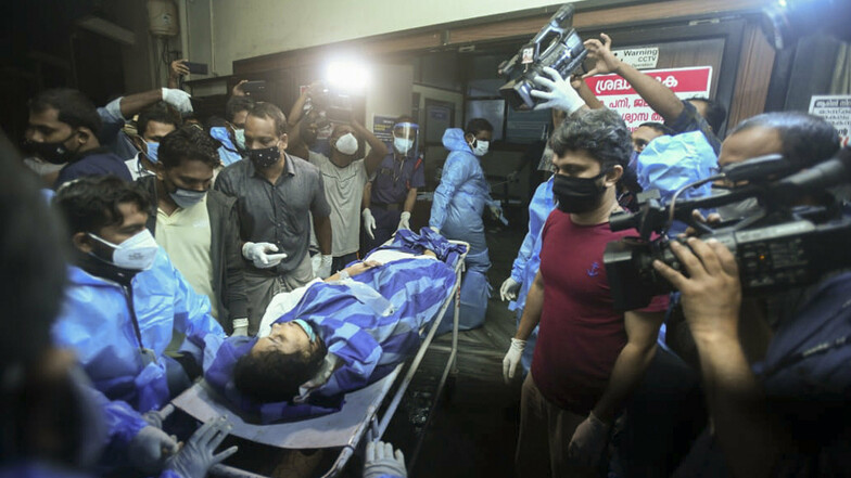 Eine der Personen, die verletzt wurde, nachdem ein Air India Express-Flug bei der Landung auf dem Flughafen von Kozhikode von einer Startbahn gerutscht war, wird zur Behandlung in das Krankenhaus der Medizinischen Hochschule gebracht.