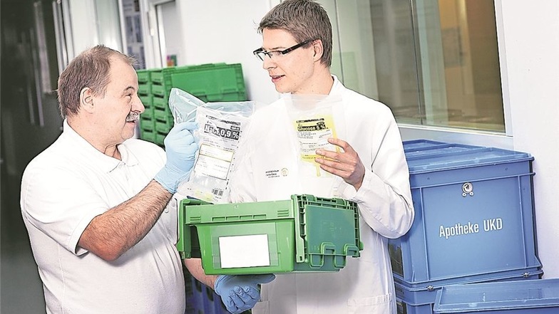 Alle halbe Stunde packt Bufdi Trix Friedrich Becker eine Transportbox. Peter Gärtner (r.) organisiert und überwacht die Abteilung Arzneimittelherstellung.