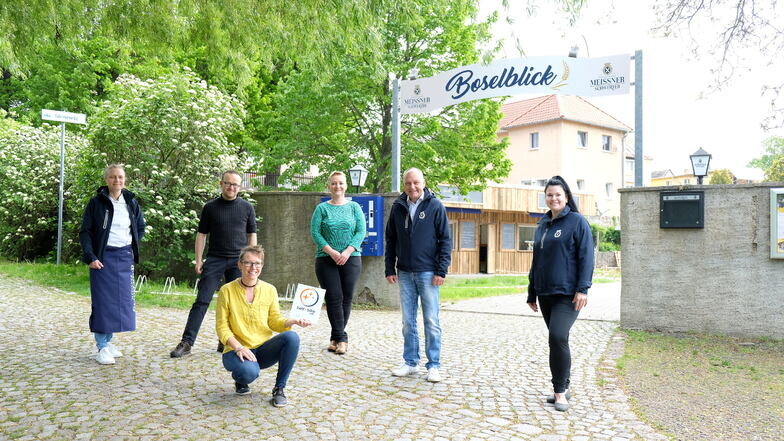 Tourismusexpertin Janine Häser (hockend) und der sächsische ADFC-Geschäftsführer Konrad Krause (2.v.l.) übergaben dem Team vom Boselblick in Sörnewitz das Bett+Bike Zertifikat.