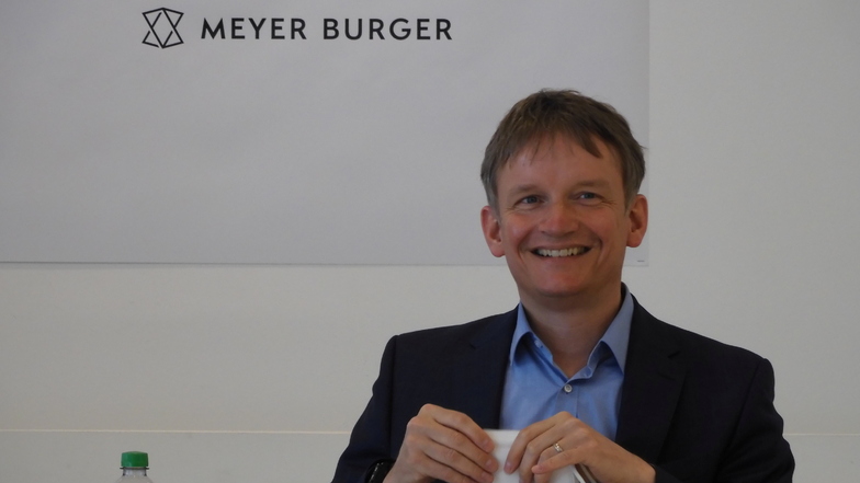 Geschäftsführer Gunter Erfurt vor dem neuen Logo von Meyer-Burger in Freiberg.