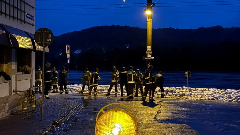 Laubegaster Feuerwehrleute am Sonntagabend gegen 20 Uhr vor einer Sandsackbarriere an der Elbe.