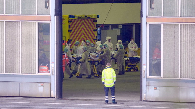 Hamburg: Rettungskräfte verteilen Corona-Patienten aus Bayern in einem Hangar am Helmut-Schmidt-Airport auf Rettungsfahrzeuge.