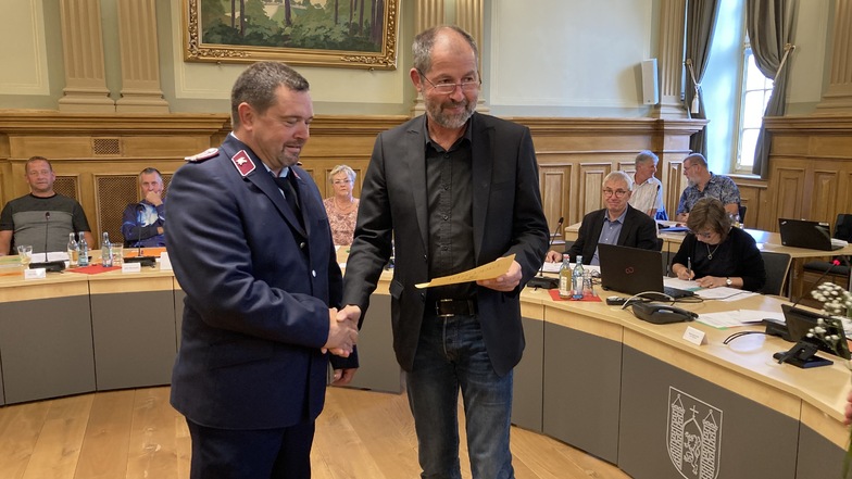 Stanley Scholz bekommt von Oberbürgermeister Albrecht Gubsch die Ernennungsurkunde zum Stadtwehrleiter überreicht.