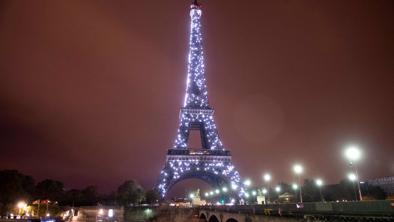 Eine beleuchtete Pont d'Iena führt zum Eiffelturm. Bald leuchtete der Eiffelturm in Paris nicht mehr bis tief in die Nacht, um Strom zu sparen.
