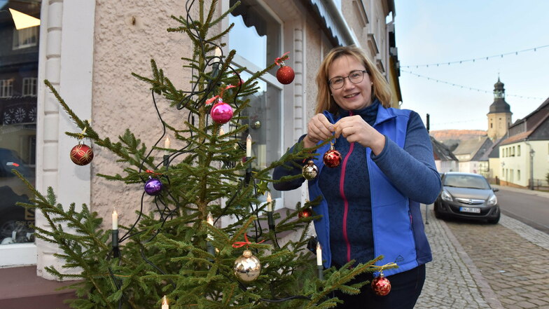 Katrin Lohse vom Geisinger Sportgeschäft schmückt bereits den Weihnachtsbaum vor dem laden auf der Hauptstraße.