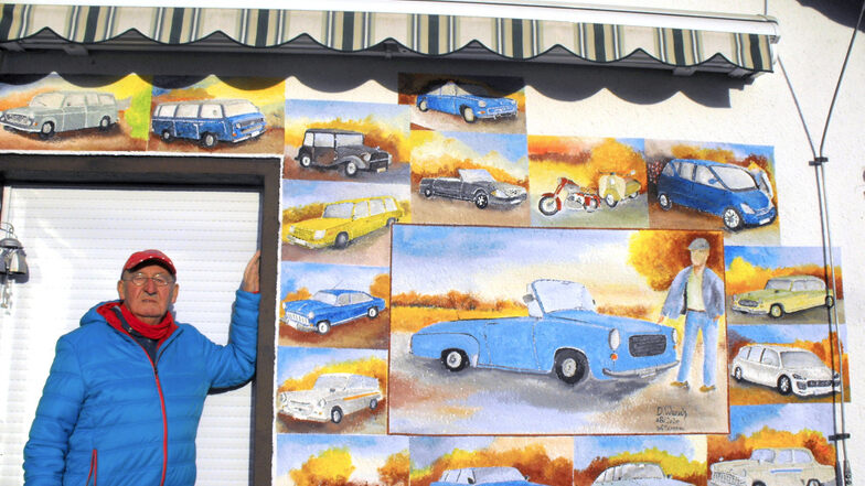 Werner Hantschke vor seiner Autowand mit Porträts all der Modelle, die er bisher gefahren hat. Den größten Teil und zentralen Platz nimmt natürlich der himmelblaue Wartburg 312/300 HT ein – aber auch Trabant P 50 Kombi, Škoda Octavia, Sachsenring,