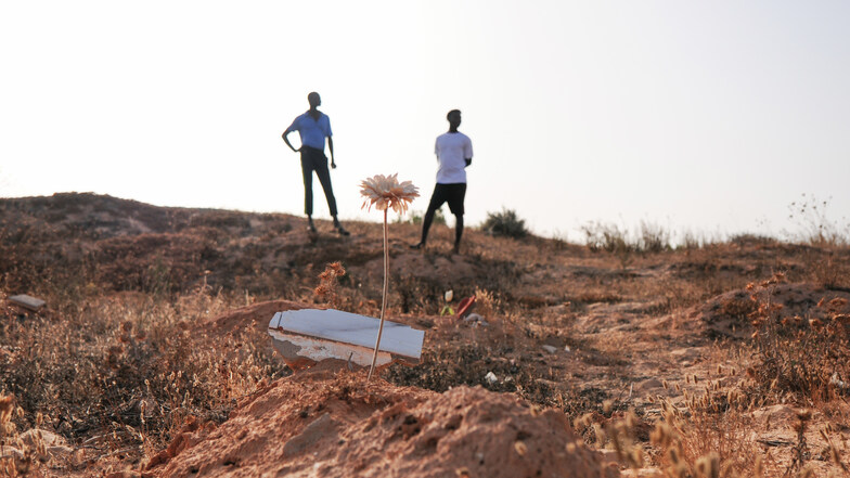 Mamadou Kamarra (l), und Ousmane Koulibali, beide aus Mali, stehen am "Friedhof der Unbekannten". Kamarra und Koulibali sind Überlebende eines Schiffsunglücks vor Tunesien.