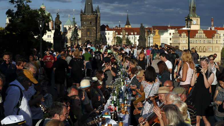 In Prag sitzen Anwohner zum Essen an einem 500 Meter langen Tisch auf der Karlsbrücke und feiern die Lockerung der Corona-Einschränkungen