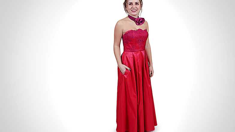 Cynthia Staneker trägt einen Traum in Rot von Designerin Tatjana Löwen aus Dresden. Eine übergroße Blume schmückt den Hals und ergänzt das Kleid raffiniert.