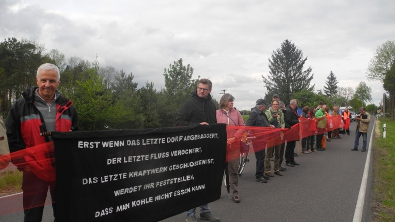 Mit einem symbolischen roten 80 Meter langen Band entlang der Straße Schleife-Mühlrose demonstrierten die Teilnehmer für wirksamen Schutz der Orte im Schleifer Kirchspiel vor Lärm, Staub und Rutschungsgefahren.