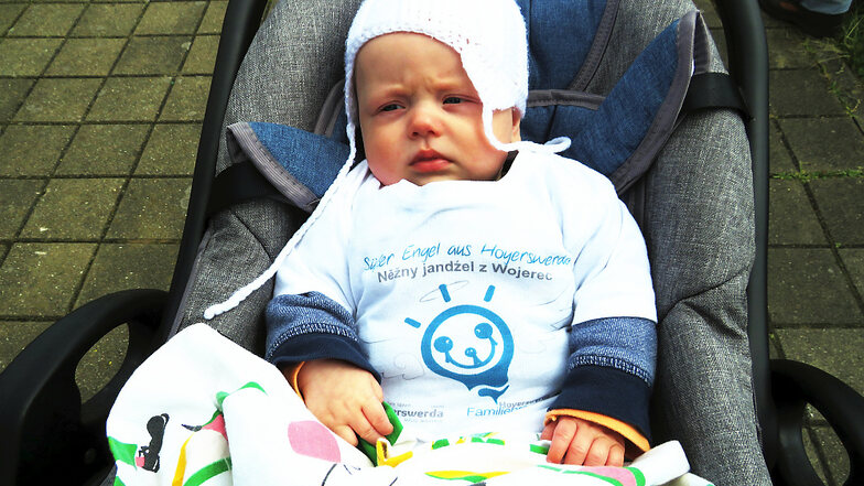 Das ist Alexander. Der vier Monate alte Junge trägt ein Shirt mit deutsch-sorbischer Aufschrift „Süßer Engel aus Hoyerswerda“. Mutter Susanne Wussow freute sich sehr über das Willkommensgeschenk, auch wenn ihr kleiner Sohn hier etwas skeptisch sch