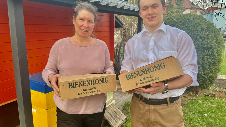 Isabel und ihr Sohn Pascal Gruhne aus Großenhain mit zwei von elf Honigkisten, die die Freizeitimker jetzt verschenken.