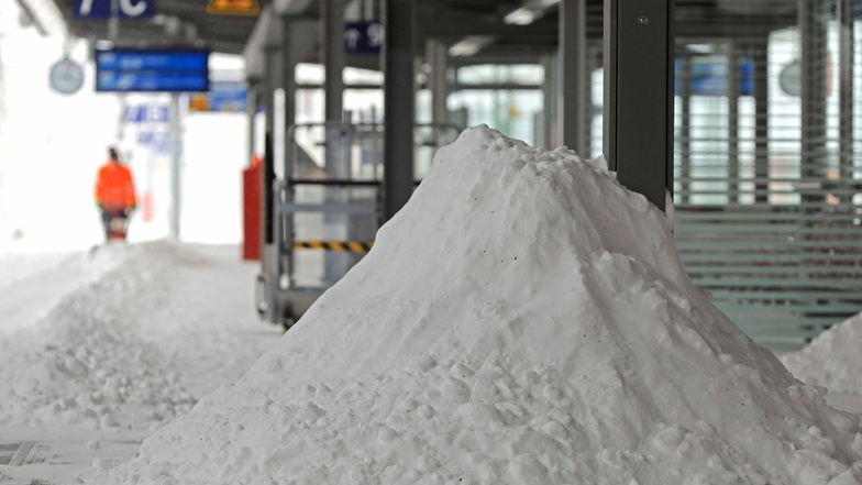 Sachsen-Anhalt, Magdeburg: Ein Mitarbeiter der Deutschen Bahn räumt auf einem Bahnsteig des Hauptbahnhofs Schnee.