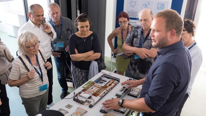 Lars Haupt vom DZA (rechts) erklärt interessierten Gästen anhand von verschiedenen Datenträgern, was das Großforschungszentrum in Görlitz machen wird.