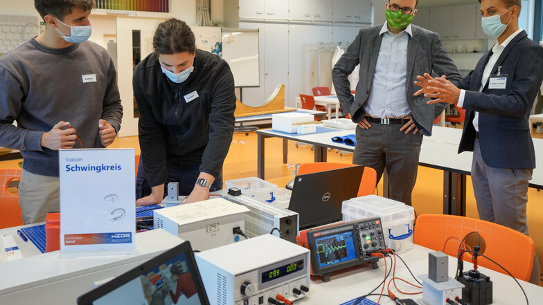 Schüler aus Riesa untersuchen den elektrischen Schwingkreis, Kultusminister Christian Piwarz (2.v.r.) schaut zu. Links Radoslav Vanko.