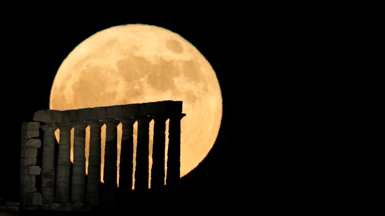 Der Mond geht hinter dem antiken Poseidon-Tempel am Kap Sounion, etwa 70 Kilometer südlich von Athen, Griechenland, auf.