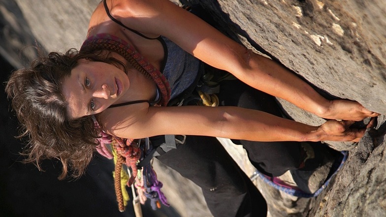 Sonnenseite, trockener Fels. Melanie Ziegelmeier steigt den Kletterweg Partisanenhangel am Gipfel Partisan in den Affensteinen