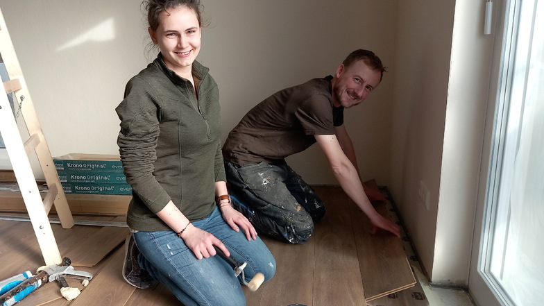 Janine Hauptvogel und Thomas Borstnitz dürfen in ihrer neuen Wohnung im ersten Gröditzer E-Mobil-Haus vieles mitbestimmen und selbst gestalten, so wie hier das Laminat.