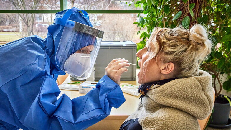 Einmal Mund auf, bitte: Kathleen Molnar (rechts) aus Sebnitz lässt sich im Sportforum Neustadt kostenlos auf das Corona-Virus testen.