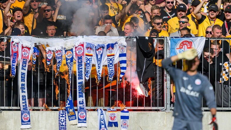 Dynamos Fans im K-Block verbrennen Rostocker Fanschals.