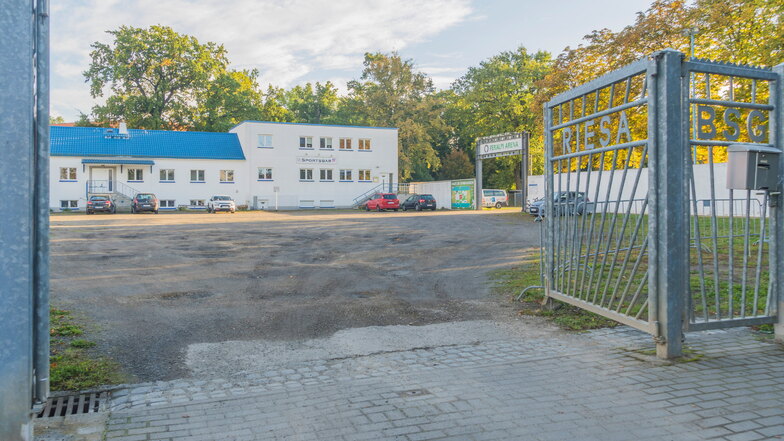 Das Tor zum Parkplatz vor der Feralpi-Arena in Riesa-Merzdorf. Die Fläche ist voller Löcher. Das soll sich bald ändern.