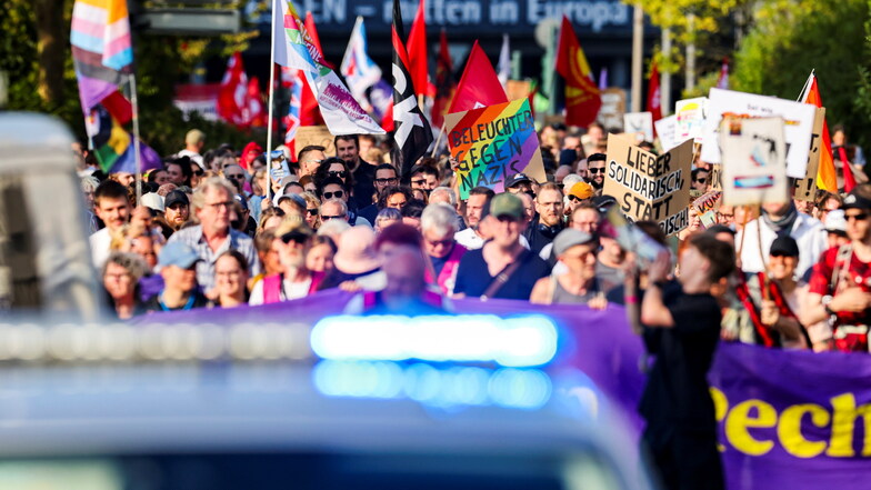 Demonstranten tagen Schilder und Fahnen bei Protesten gegen einen "Bürgerdialog" der AfD in Essen.