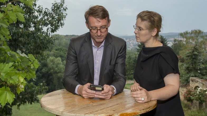 Roland Wöller und seine Ehefrau Corinna Franke-Wöller verfolgen auf Gut Pesterwitz am Handy die Zwischenstände am Wahlabend.