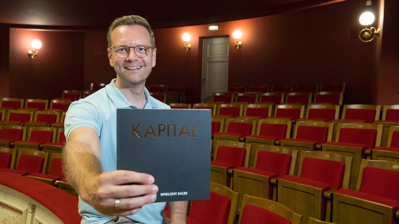 Daniel Morgenroth, Intendant des Gerhart-Hauptmann-Theaters Görlitz/Zittau, mit dem Programmheft der neuen Spielzeit mit dem Titel „Kapital“.