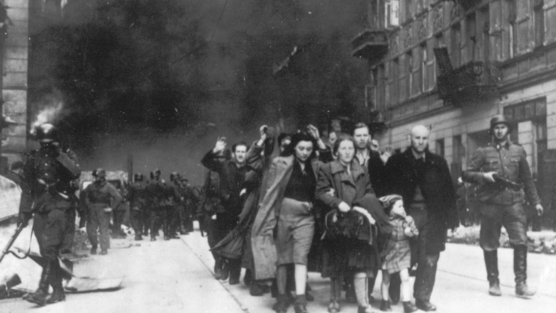 Auf dem Foto aus dem Jahr 1943 wird eine Gruppe polnischer Juden während der Zerstörung des Warschauer Ghettos durch deutsche Truppen zur Deportation durch deutsche SS-Soldaten abgeführt.
