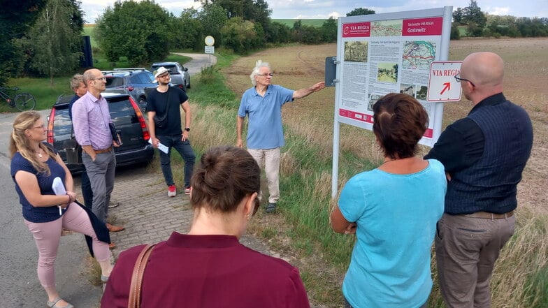 Peter Griepentrog zeigt den Juroren des Landratsamtes Meißen die Tafel an der Via Regia bei Gostewitz.