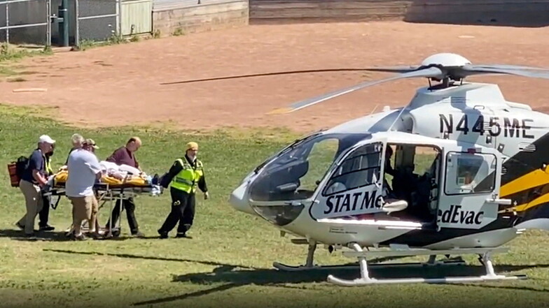 Autor Salman Rushdie wird auf einer Trage zu einem Hubschrauber gebracht, der ihn in ein Krankenhaus transportiert.