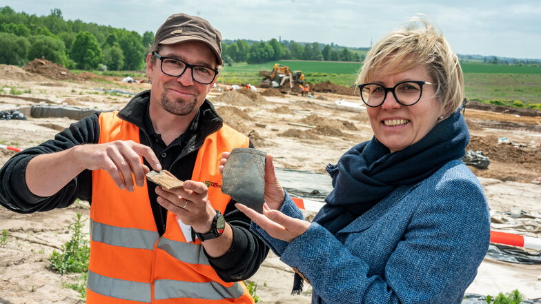Thomas Lukas vom Archäologenteam macht  Staatsministerin Barbara Klepsch mit Fundstücken der Grabungen bei Karls Erlebnis-Dorf vertraut.