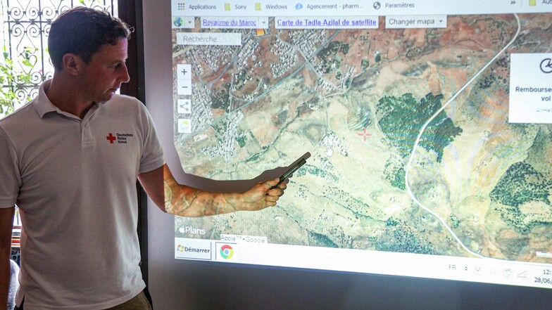 DRK-Krisenmanager Lars Werthmann zeigt an einer Übersichtskarte  das Einsatzgebiet der sächsischen Ausbilder im Hohen Atlas.