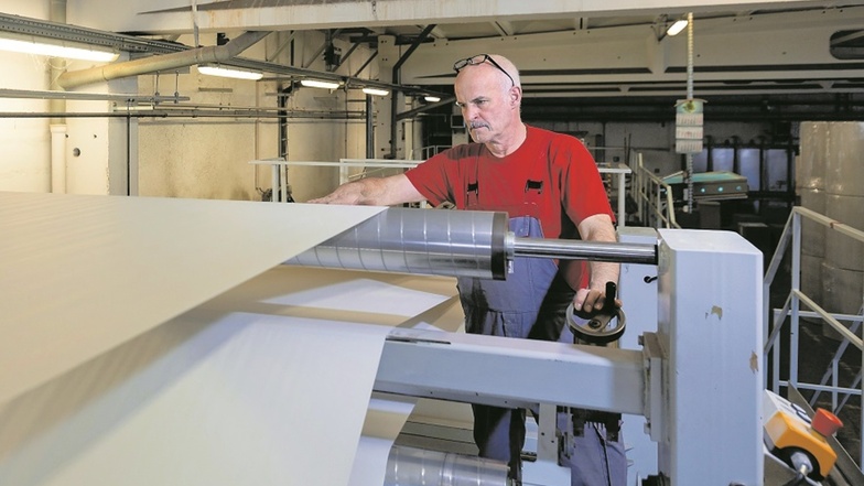 René Iltzsche schneidet das Papier in der Papierfabrik Hainsberg in großen Bögen zu. So können sie zum Kunden transportiert werden.
