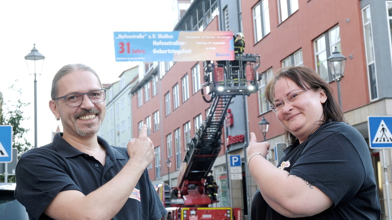 Giovanni Sieg-Teucher und Bianca Lietricz vom Hafenstraße e.V. rühren die Werbetrommel fürs Hafentraßenfest. Die Feuerwehr ist dabei behilflich.