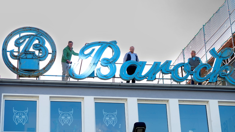 Die DDR-Leuchtreklame des ehemaligen Tintenherstellers "Barock" in Dresden soll wieder strahlen. Das wollen Torsten Meisel (r.) und Benjamin Venter (M.) vom Barock-Eventpark und Gunther Lange, Geschäftsführer von "Octopus", erreichen.