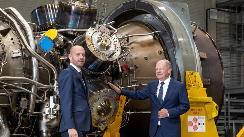 Bundeskanzler Olaf Scholz (r, SPD) steht mit Christian Bruch, Vorstandsvorsitzender von Siemens Energy, an der in Kanada für die Erdgas-Pipeline Nord Stream 1 gewarteten Turbine.