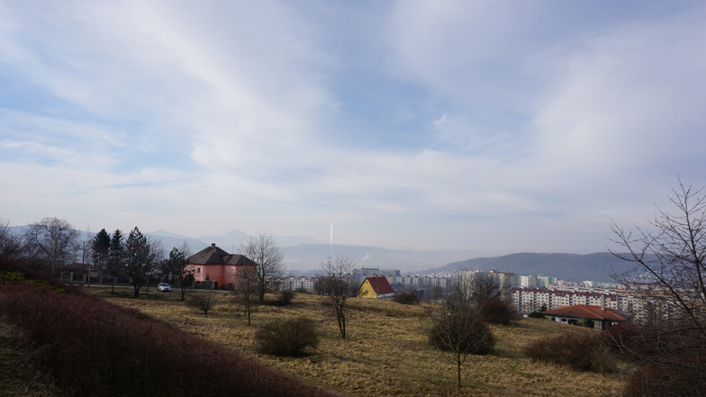 Morgendlicher Dunst über den Plattenbaugebieten und Schornsteinen von Ústí nad Labem. Im Hintergrund das Böhmische Mittelgebirge mit dem Berg Milešovka (Milleschauer).