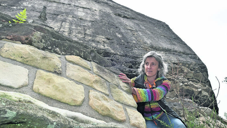 Solche Mauern aus Sandsteinquadern, wie sie Sabine Kulikov hier am Wehlturm zeigt, sollen die darunter liegende Rathener Felsenbühne vor Abbrüchen schützen.