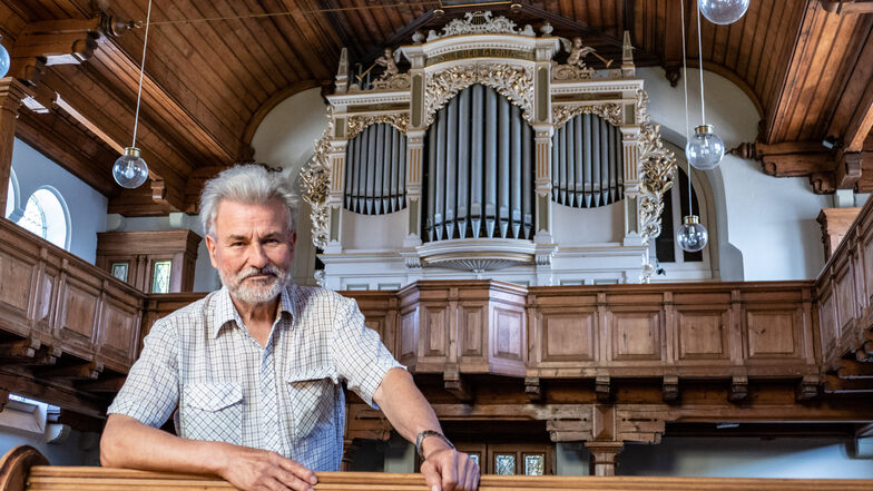 Pfarrer Reinhard Mehnert steht vor der Orgel in der Ostrauer Kirche. Er geht nach 36 Jahren in den Ruhestand.