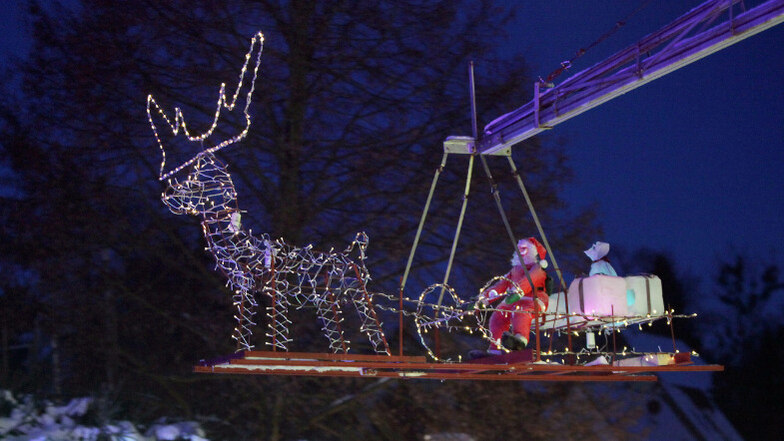 Der Weihnachtsmann schwebt in einem leuchtenden Schlitten über die Köpfe der Besucher und bringt zauberhafte Weihnachtsstimmung in die Szenerie.