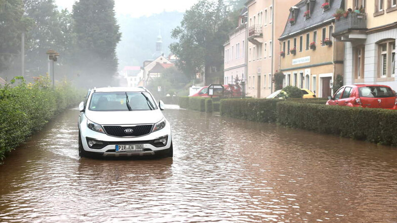 Wenn die Straße zum Fluss wird: Ein Auto auf der überschwemmten Kirnitzschtalstraße in in Bad Schandau.