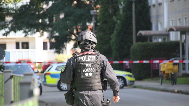 Ein Polizist geht in Richtung des Hauses, in dem der mutmaßliche Verdächtige lebt.