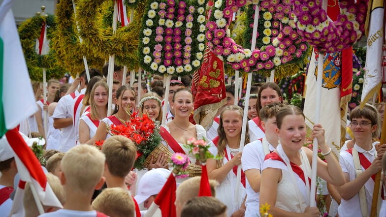 Die Stäbe, an denen beim Forstfest in Kamenz die Blütenkränze hängen, kommen seit vielen Jahrzehnten zum Einsatz. Jetzt wurden viele davon von Schülern neu angestrichen.