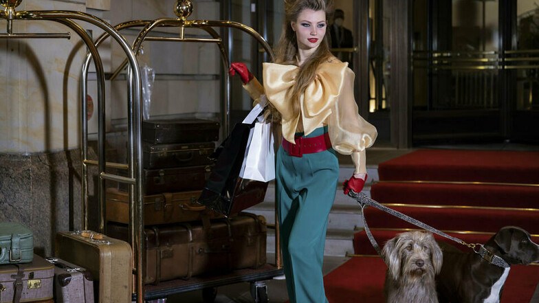 Auf Leo-Print-Rollschuhen und mit zwei großen Hunden an der Leine posiert GNTM-Kandidatin Romy vorm Berliner Adlon-Hotel.