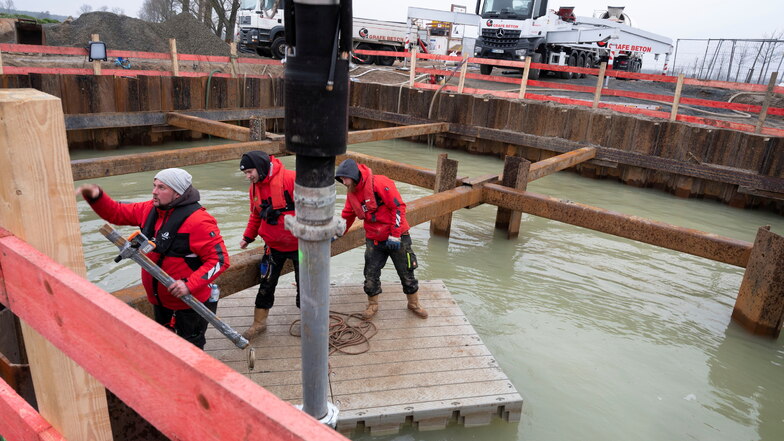 Die Mitarbeiter einer Spezialfirma bringen in der überfluteten Baugrube bei Lichtensee Hunderte Kubikmeter Unterwasserbeton ein.