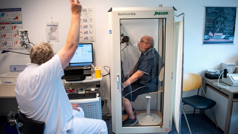 Reinhard Janzen sitzt zur Überprüfung seiner Lungenfunktion in einem Bodyplethysmographen