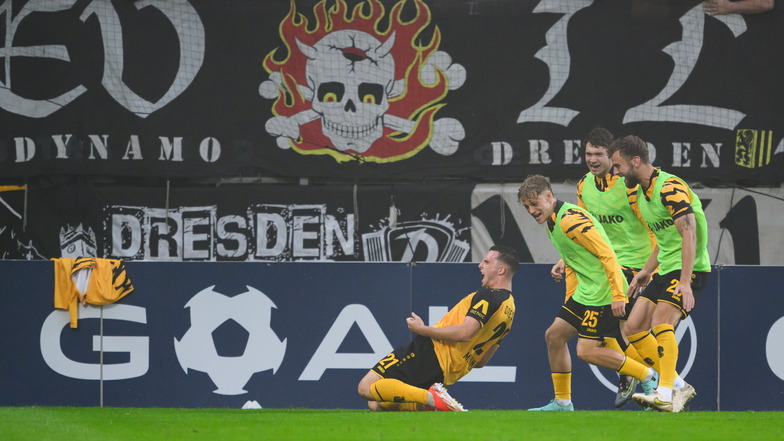 Auf den Knien rutscht Torschütze Robin Meißner in Richtung Dresdner Fans - und jubelt mit den am Rand stehenden Auswechselspielern.